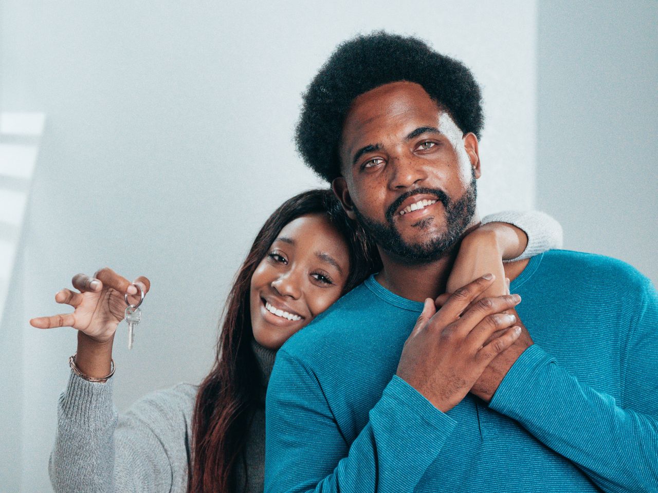 The Art of Drawing Readers In: Your attractive post title goes here Joyful couple proudly holding keys to their new home, symbolizing fresh beginnings.
